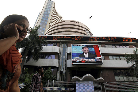 A woman speaks on her phone as she walks past the Bombay Stock Exchange.