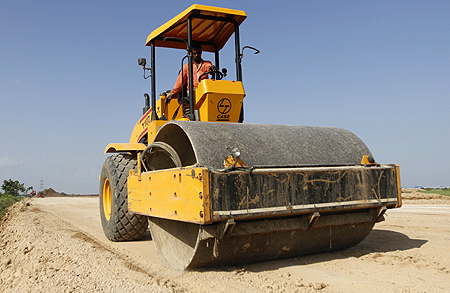 A worker drives a road-roller during road construction near the proposed Ford car plant in Sanand.