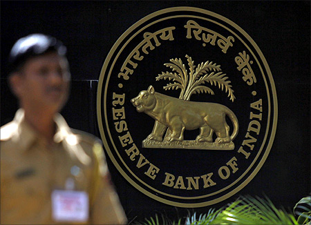 A policeman walks past the logo of the Reserve Bank of India (RBI) outside its head office in Mumbai.