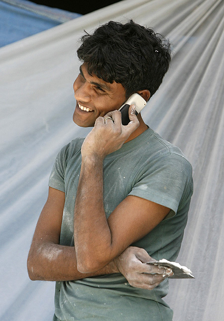 A labourer talks on his mobile phone at a construction site in New Delhi.