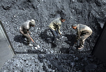 Labourers load coal on trucks at Bari Brahamina on the outskirts of Jammu.