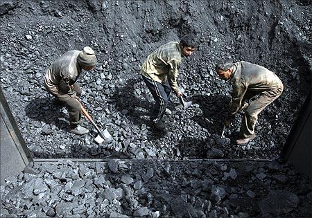 Labourers load coal on trucks at Bari Brahamina on the outskirts of Jammu.