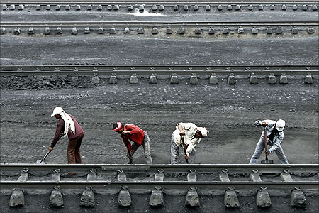 Men work inside a coal yard as they clear coal from a railway track near Ahmedabad.
