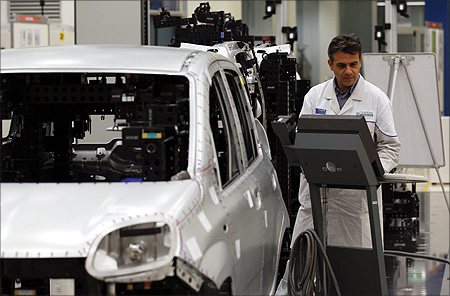 An employee of Fiat performs a quality control check on the new Panda car at the Fiat plant in Pomigliano D'Arco, near Naples.
