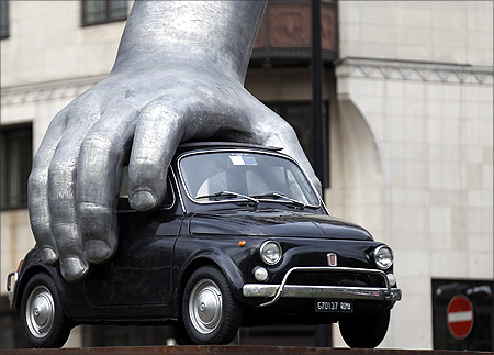 A Fiat 500 gripped by an aluminum hand is seen in Italian artist Lorenzo Quinn's sculpture Vroom Vroom in London.