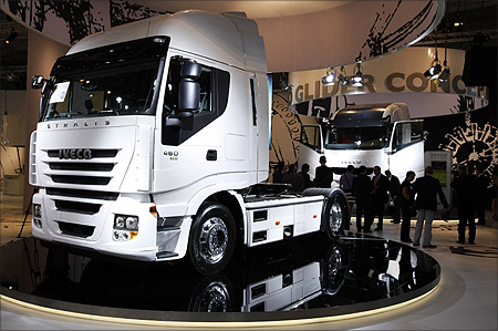 Visitors walk along a display of heavy trucks at the Fiat Iveco exhibition area during a preview day at the IAA commercial vehicles trade fair in Hanover.