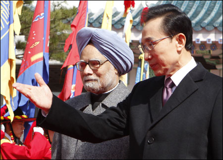 South Korean President Lee Myung-Bak (R) and India's Prime Minister Manmohan Singh walk to attend official welcoming ceremony at the presidential Blue House.