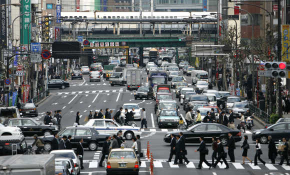 Pedestrians walk across a zebra crossing in Tokyo.