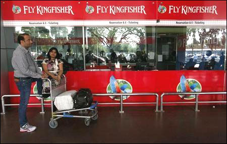 Passengers stand at a Kingfisher Airlines reservation office at the domestic airport in Kolkata.