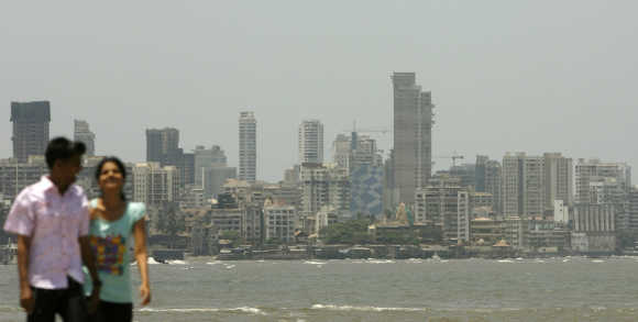 A couple walk at the seafront in Mumbai.