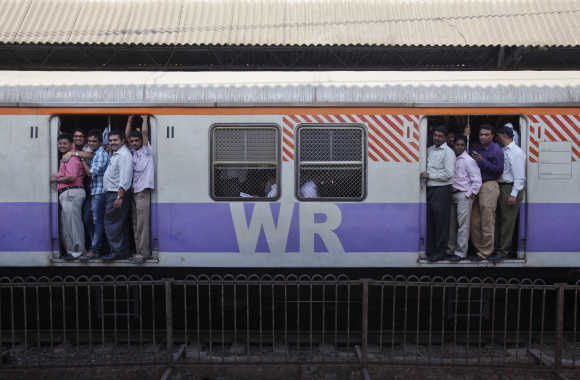Passengers ride a commuter train in Mumbai.
