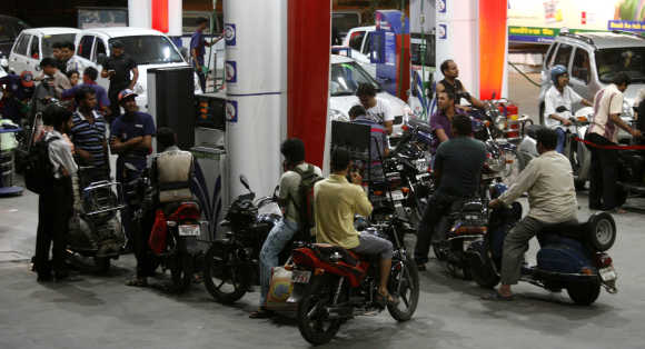 Motorists wait at a fuel station to fill petrol in Ahmedabad.