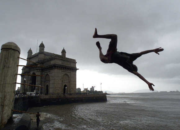 A boy jumps into the Arabaian Sea next to Gateway of India in Mumbai.