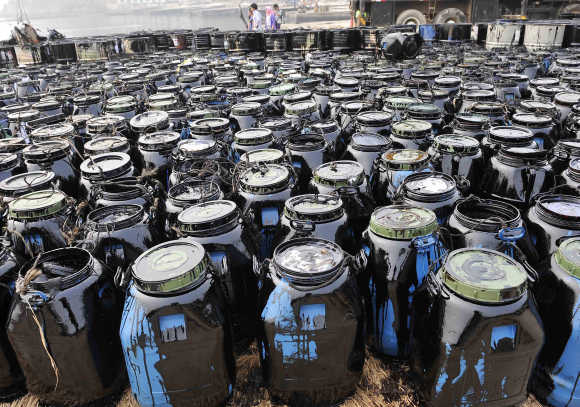 Containers filled with oil cleaned up from the oil spill site are seen at Beilianggang port in Dalian, Liaoning province, China.