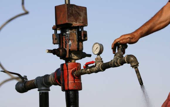 A worker turns a valve to release drilled oil, near the Dead Sea, Israel.