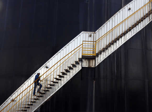 An employee of the Canadian Pacific Rubiales Petroleum Company ascends an oil storage tank in Campo Rubiales field in Meta, eastern Colombia.