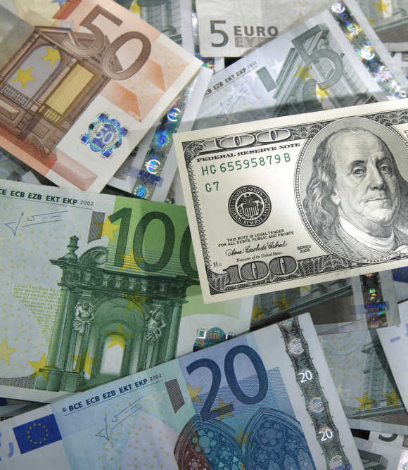 A picture illustration shows a $100 banknote on various denomination of euro banknotes in Warsaw.