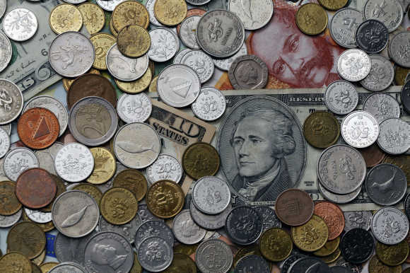 A picture illustration of coins from various countries laying on kuna and dollar banknotes in Zagreb, Croatia.