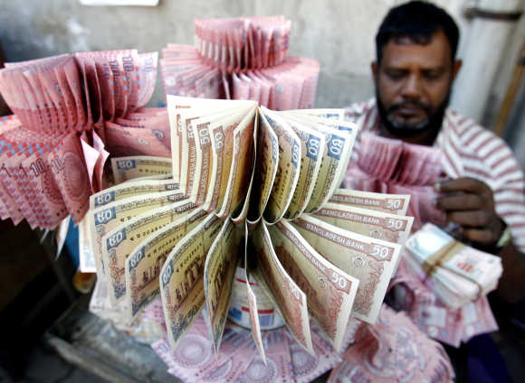 Money vendor displays crisp Bangladeshi takas of different denominations in Dhaka.