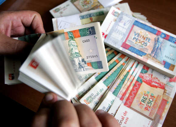 A man counts freshly printed Cuban convertible peso notes in Havana.