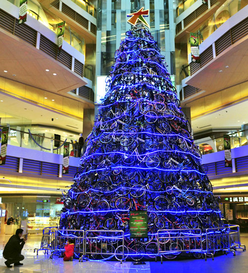 A man takes a photo for his daughter in front of a Christmas tree at a shopping mall in Shenyang.