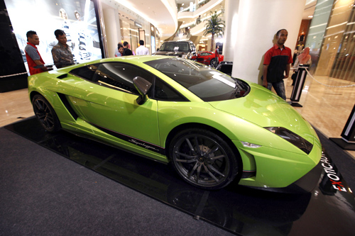 Men look at a Lamborghini on display at a shopping mall in Jakarta.