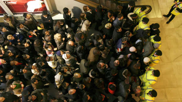 Shoppers wait for the doors to open on the first day of the Harrods sale in London.