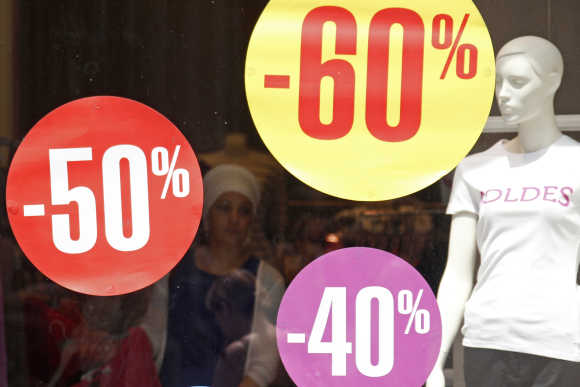 Discount signs are displayed in a clothing store window in Strasbourg, France.