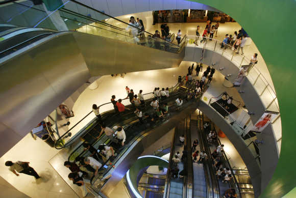 Shoppers use escalators inside a shopping mall in Singapore.