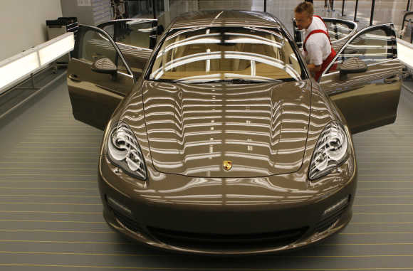 Workers of Porsche Automobil Holding SE assemble Panamera model at the production line in Leipzig, Germany.