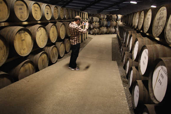 A tourist takes a photograph at Edradour distillery.