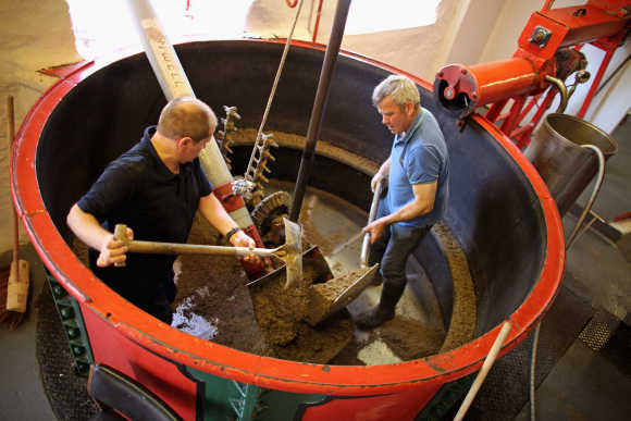Workers clear out the Mash Tun at Edradour distillery.