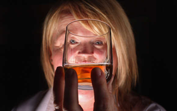 Julie Cameron, tour guide, holds a glass of whisky at Edradour distillery.