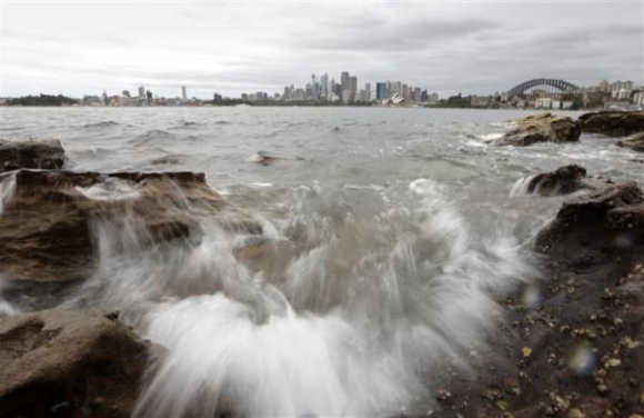 Waves wash over rocks that fringe Sydney Harbour.