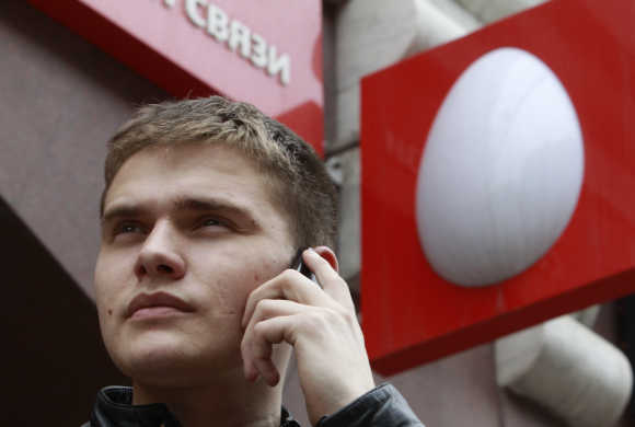 A man speaks on a mobile phone near an office of Russia's mobile phone operator MTS in Moscow.