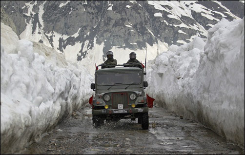 Indian army soldiers travel in a vehicle on a mountainous road covered by snow after the Srinagar-Leh highway was opened.