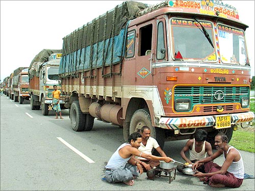 Indian truck drivers cook a meal along a highway near Boksher village.