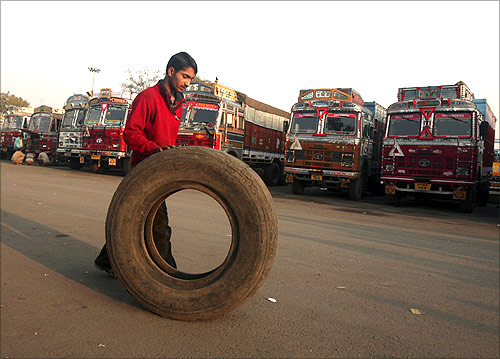 A helper rolls a tyre near the parked trucks during a strike by truckers in Chandigarh.