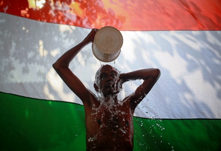 A man takes a bath outside his shanty in front of the Indian national flag in Dharavi, one of Asia's largest slums, in Mumbai.