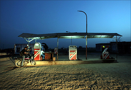 A worker pumps fuel at a petrol station at Greater Noida.