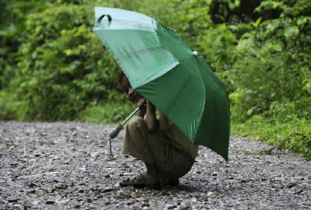 A boy reacts to the camera during a monsoon shower in a village in Uttarakhand