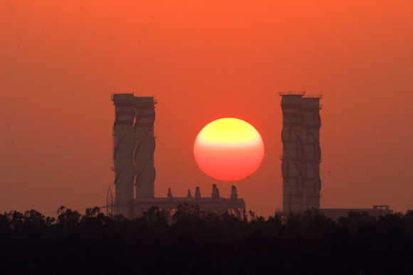 Sun sets behind chimneys of a thermal power station in New Delhi.