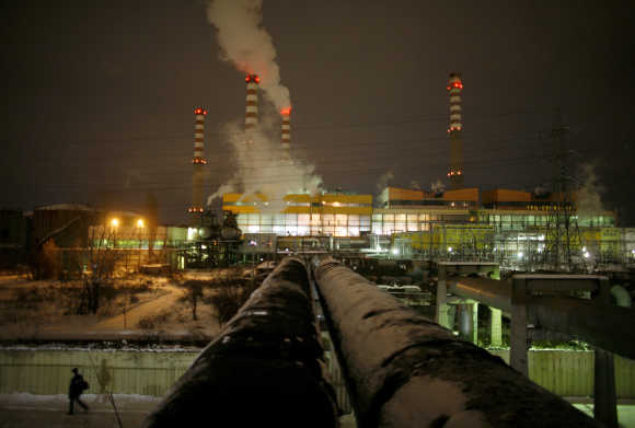 Man passes by pipes coming out of Druzhba thermal power station in Sofia.