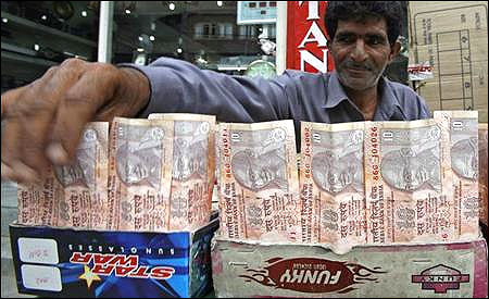 A Kashmiri money changer Nissar Ahmad displays newer Indian rupee notes in Srinagar on July 21, 2008.