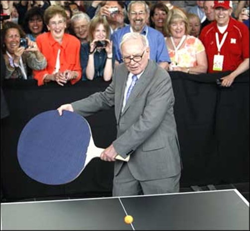 Berkshire Hathaway chairman Warren Buffett plays table tennis using a giant paddle.