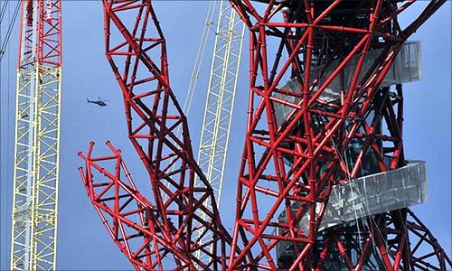 A helicopter flies near the Anish Kapoor designed ArcelorMittal Orbit tower at the Olympic site at Stratford in east London.