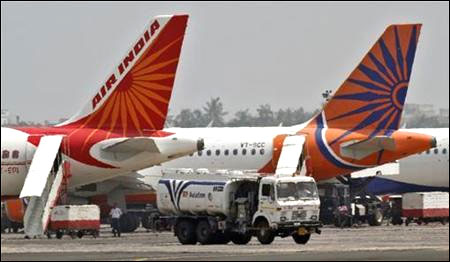 A fuel tanker moves past Air India passenger jets.