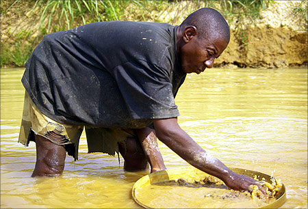 A miner washes muddy gravel in the hope of finding diamonds