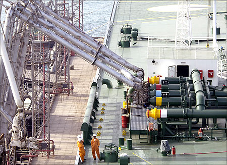 Kuwait Oil Tanker employees oversee the loading of crude oil into the new Kazimah III Oil Tanker at Ahmadi North Pier in Kuwait.