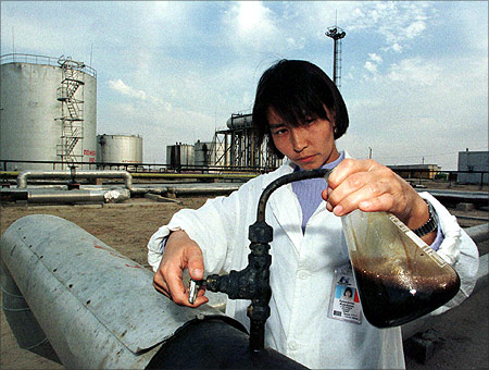 A Kazakh specialist takes crude oil for analysis at the Kumkol oil field near western Kazakh city Kuzul-Orda in this September 1997 file photo.